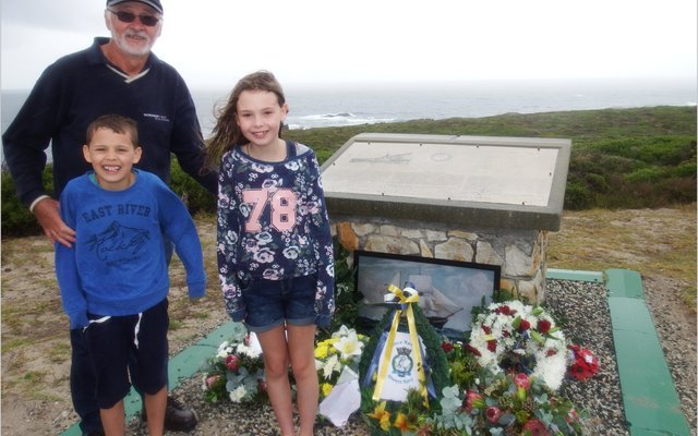  Thys de Wet met sy twee kleinkinders wat vanaf Engeland kom kuier het, Zach (9) en Kendra (10) Bardon, met Kendra wat ook ‘n krans gelê het